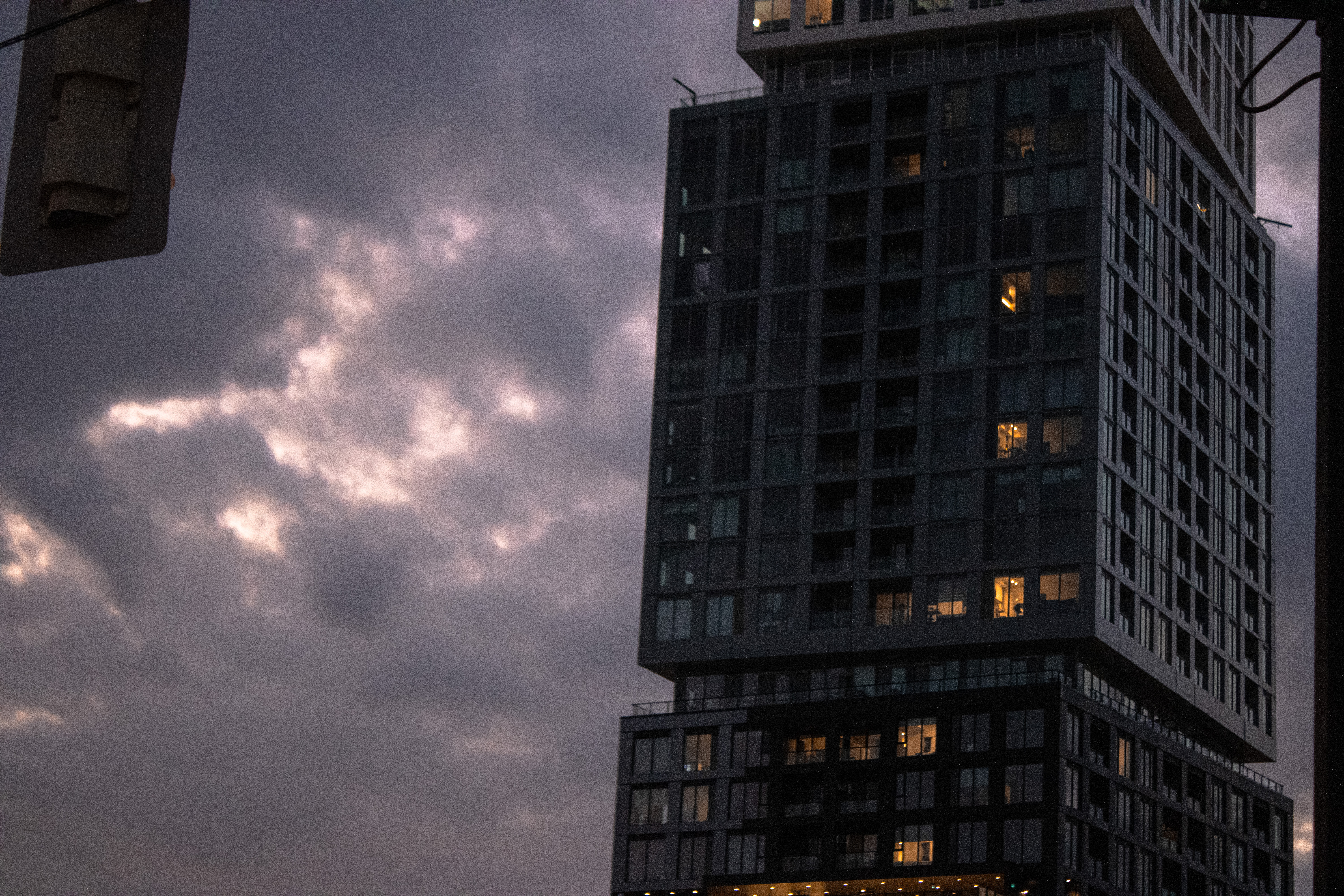 High-rise tower under storm clouds at dusk